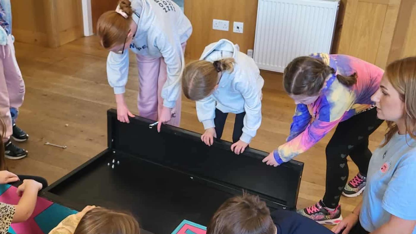 Pupils building the car chassis with a teacher